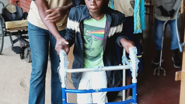 Hillary assisting Joshua to walk using the walker.jpg